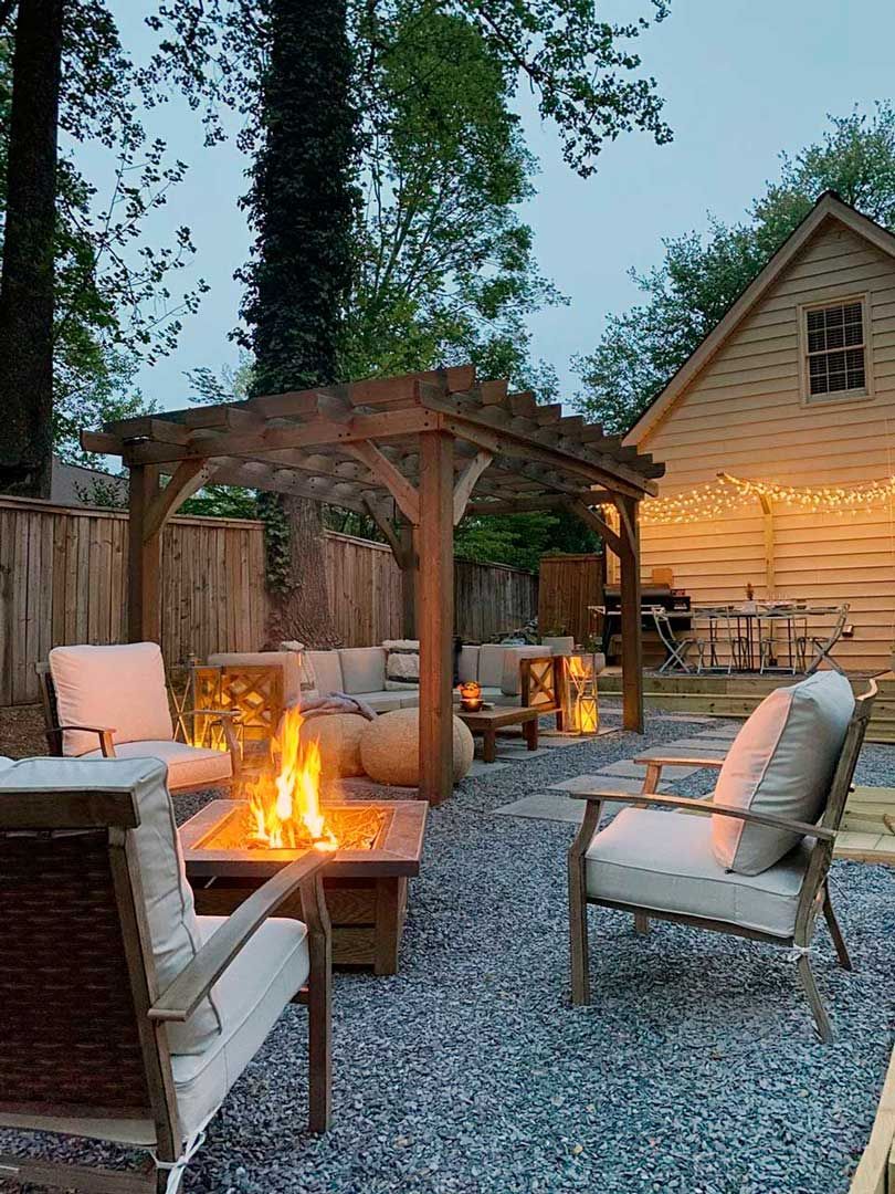 Outdoor space for relaxation with pergola, fire pit, landscaping lighting, and stone floor