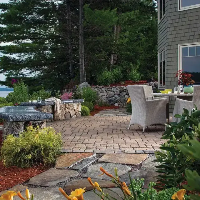 A patio with a table and chairs in front of a house