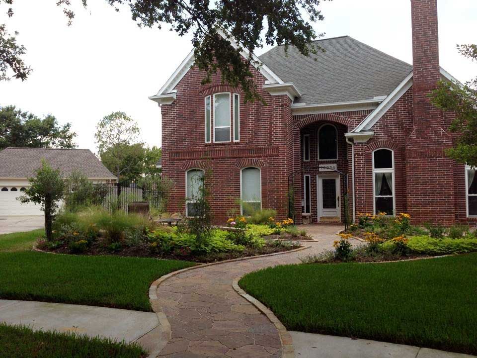Beautiful stone path surrounded by grass and landscaping beds