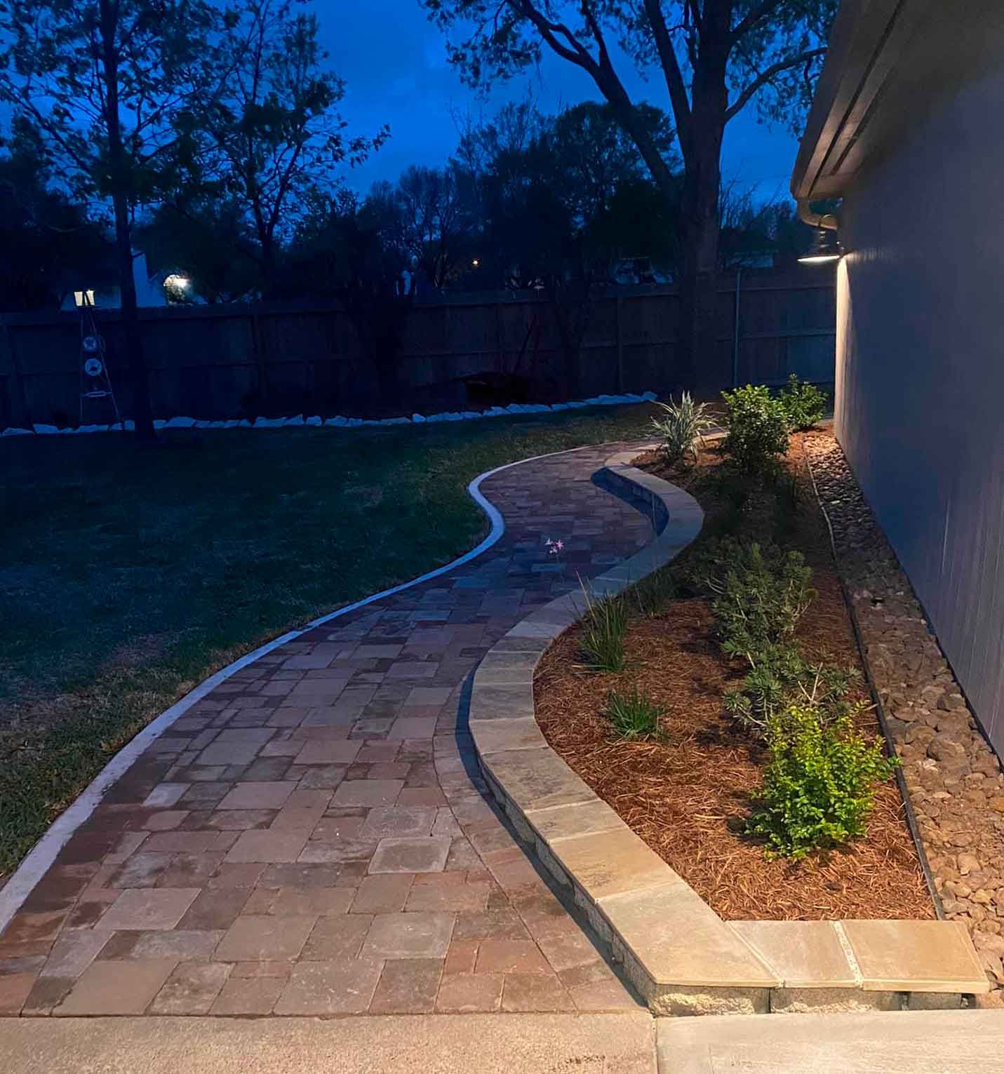 Paver pathway with landscaping bed on the house side