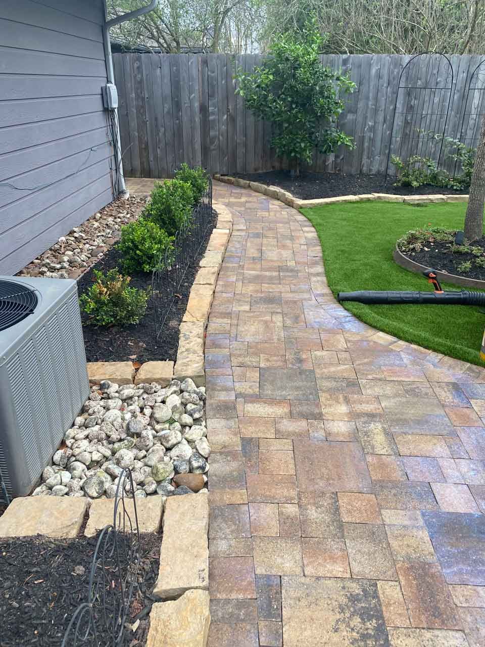Stone bricks walking path in the backyard with landscaping