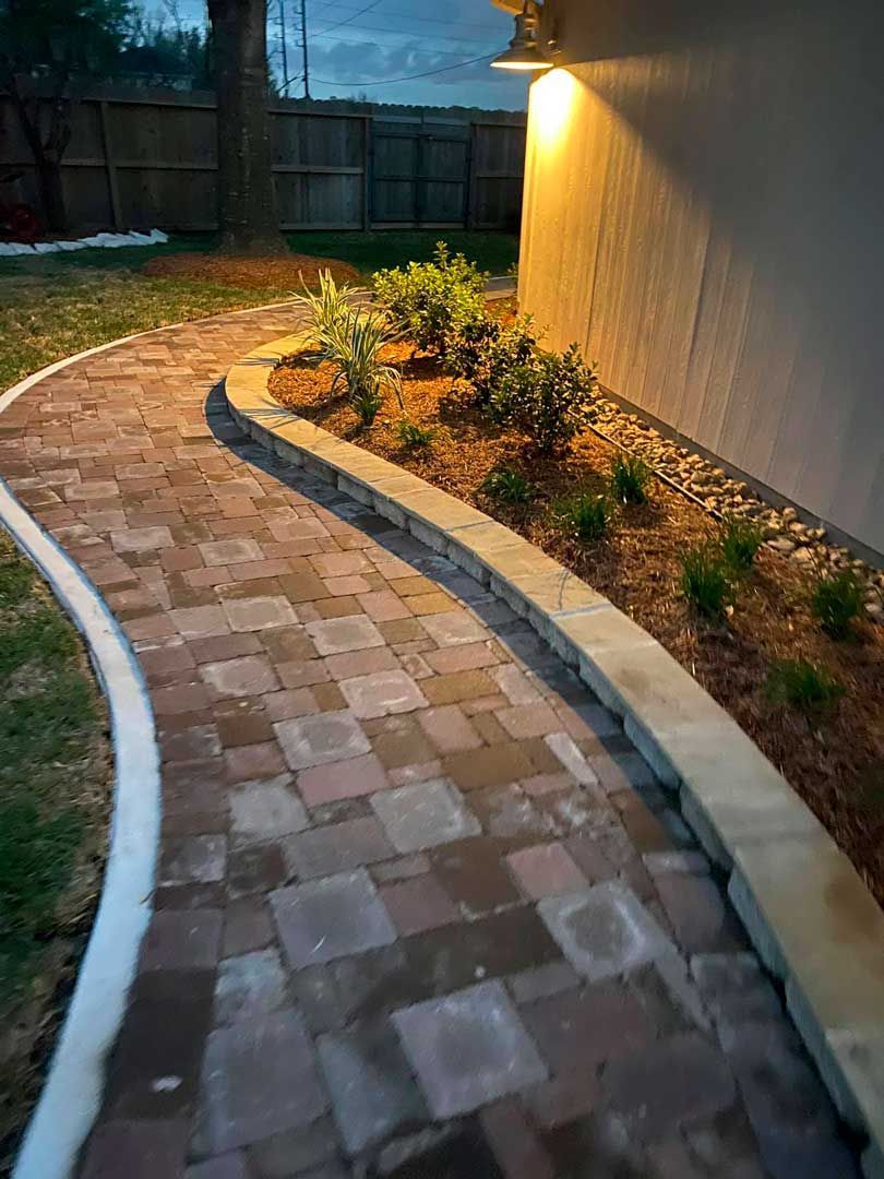 Brick pathway with landscaping bed on the side