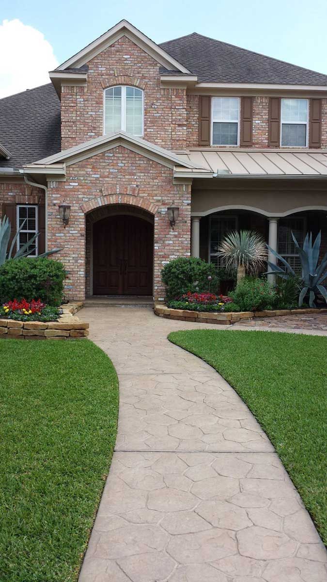 Beautiful entrance decorated with landscaped stone beds and a central pathway
