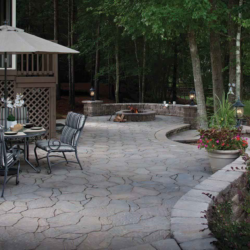 Large patio of grey stones with a fire pit
