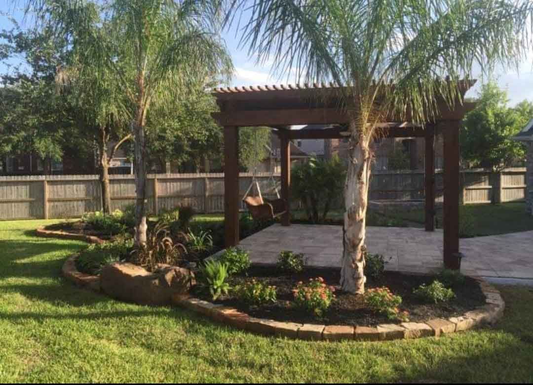 Solid wood pergola in a backyard with landscaping beds