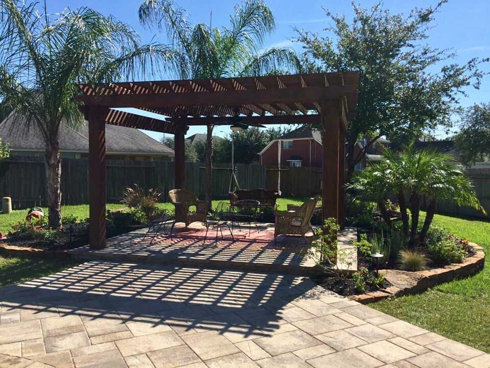 Pergola in backyard with paver area and palm trees