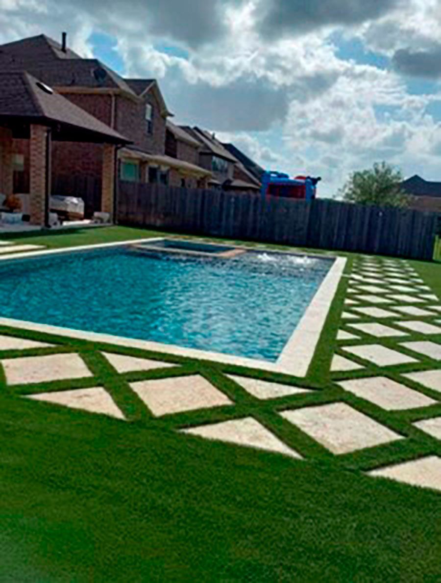 Swimming pool in the backyard with turf landscape.