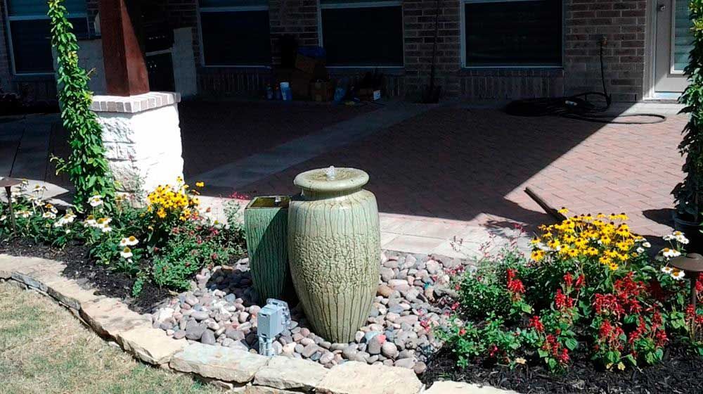 Small landscaping of river stones with a pondless water fountain