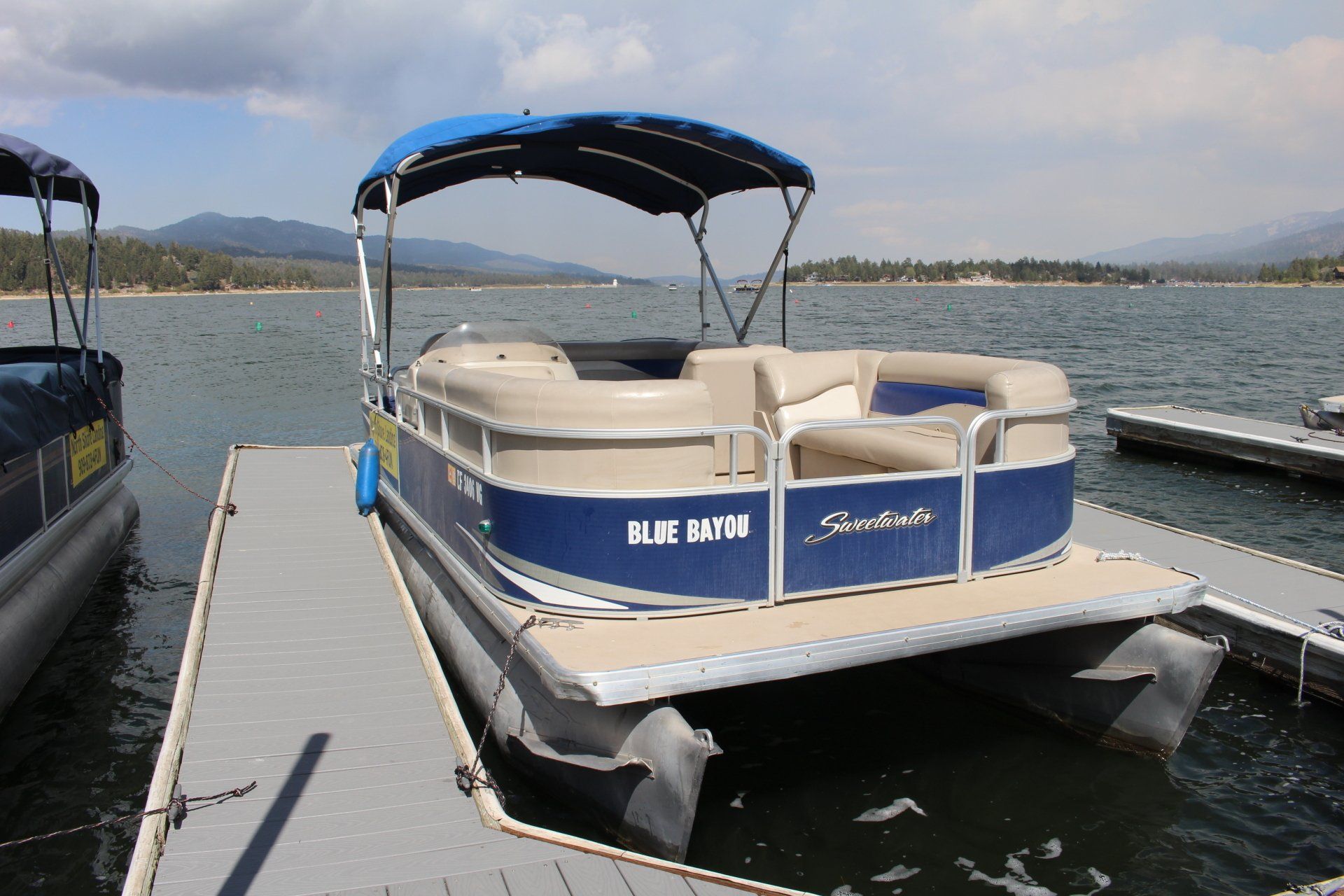Blue and white cruising pontoon boat in Big Bear Lake