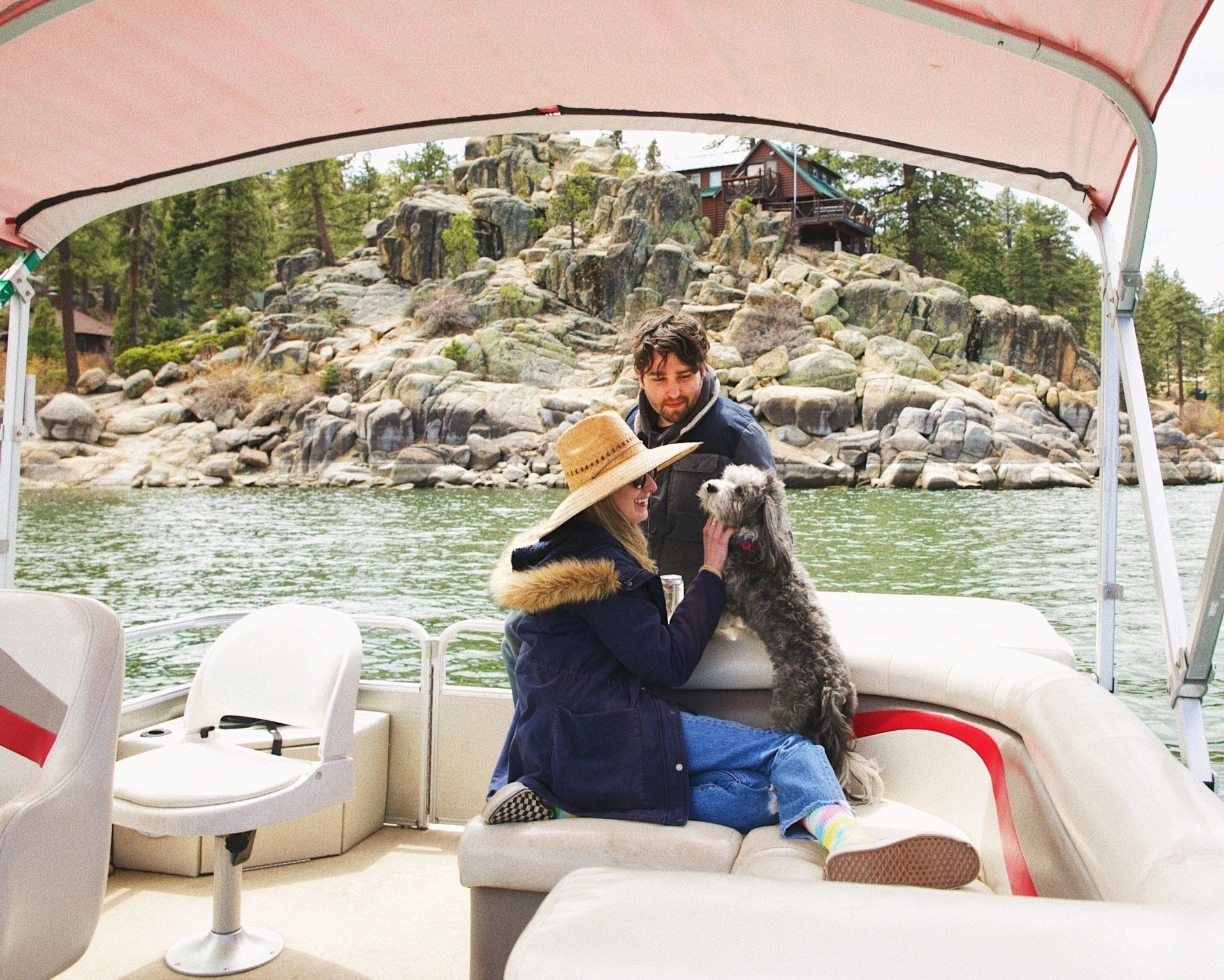 Couple with dog on pontoon boat