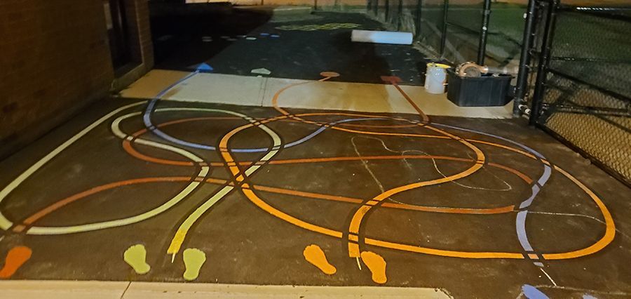 Playground markings: intertwined, colorful lines painted on asphalt. Footprints at the starting points.