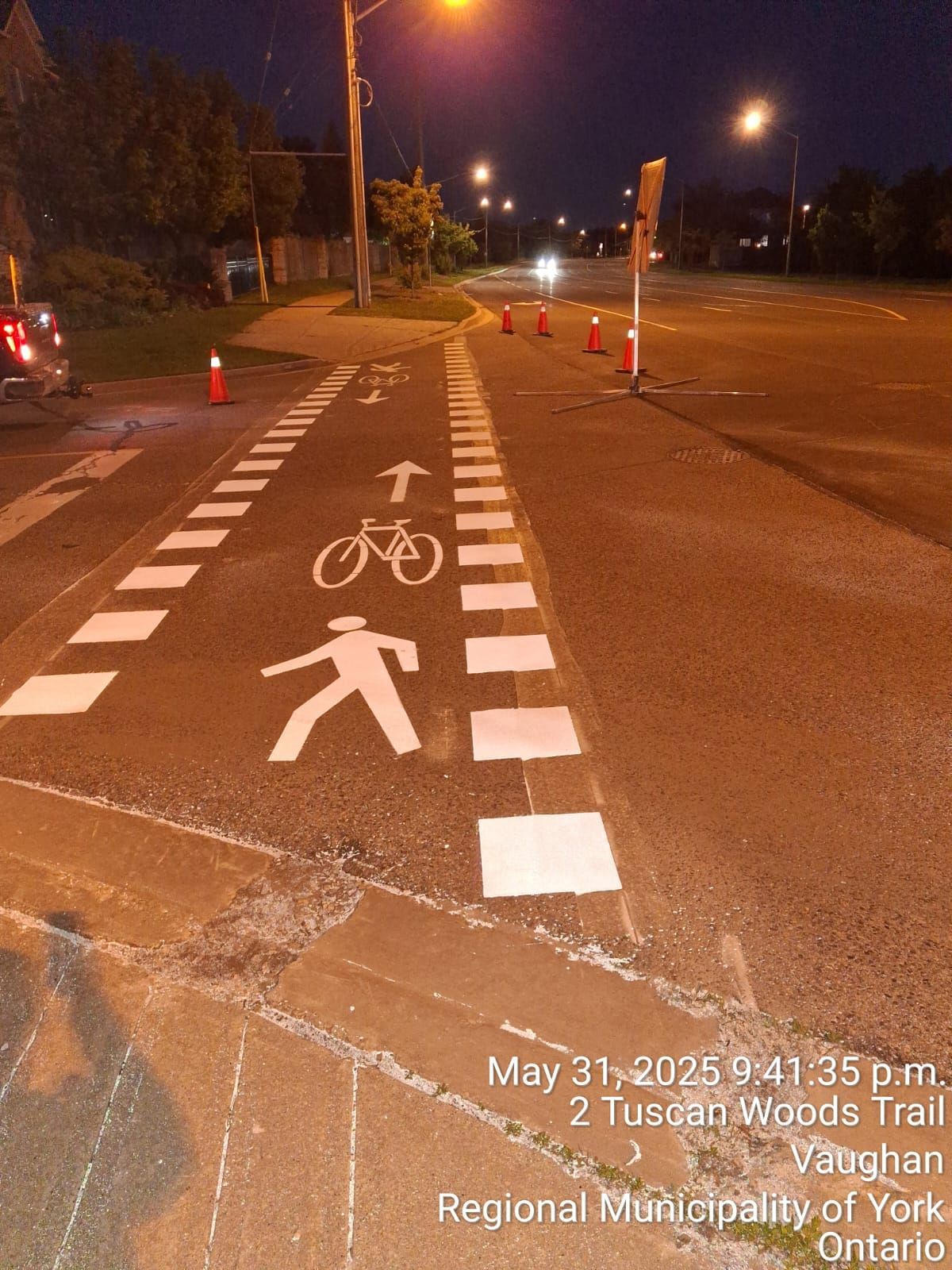 Bike and pedestrian path on Tuscan Woods Trail, Vaughan, Ontario, at night, marked with paint and cones.