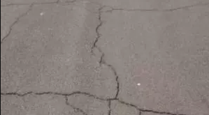 Gray concrete surface with multiple cracks.