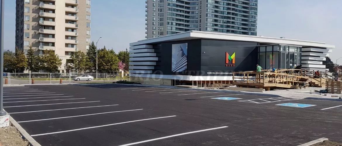 A McDonald's restaurant with a mostly empty parking lot in front of it. Tall buildings in the background.
