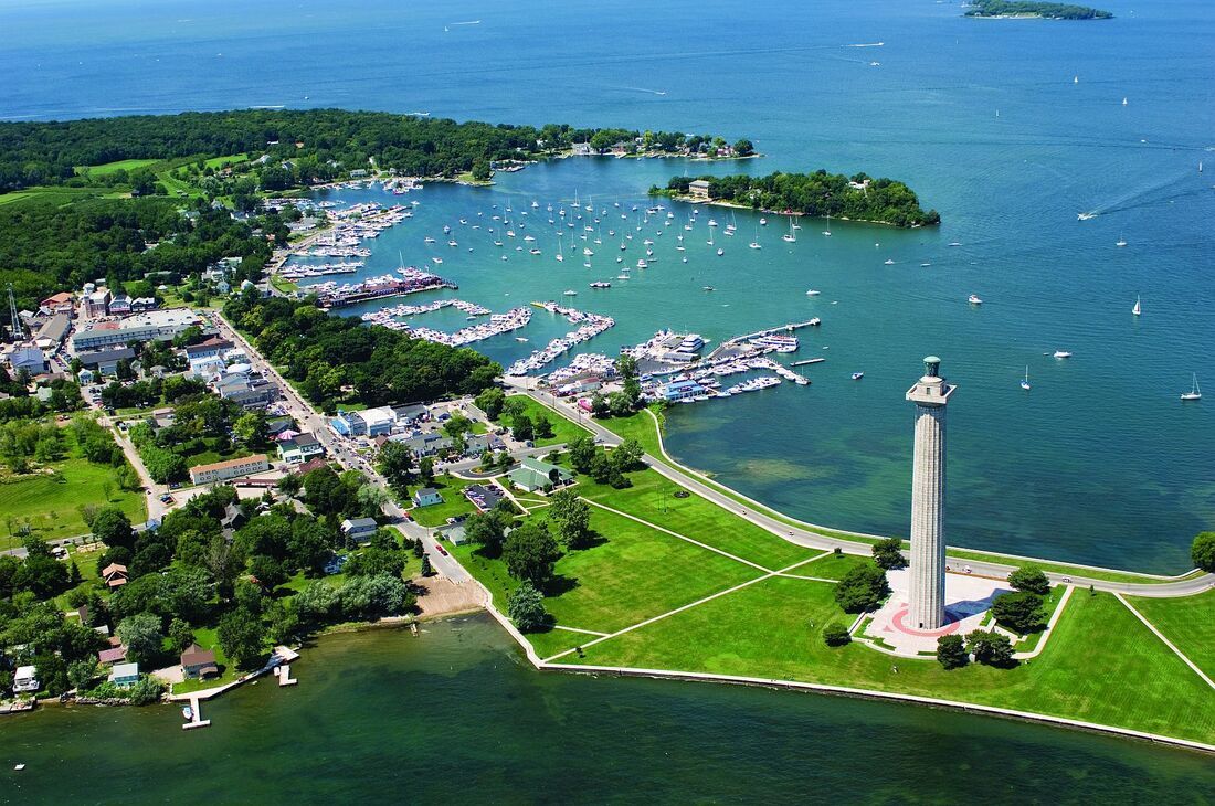 An aerial view of a lighthouse in the middle of a body of water.