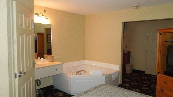 A hotel room with a jacuzzi tub in the corner