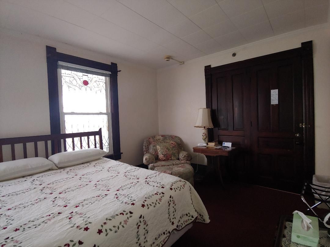 A bedroom with a bed and a chair in it