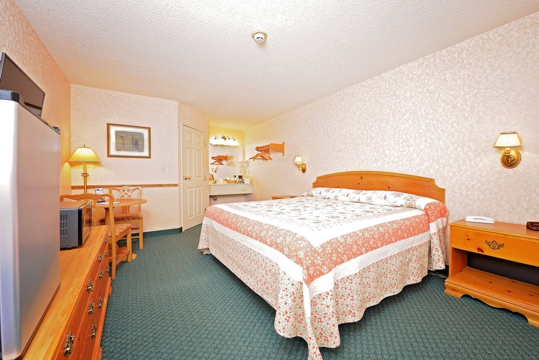 A hotel room with a king size bed and a flat screen tv