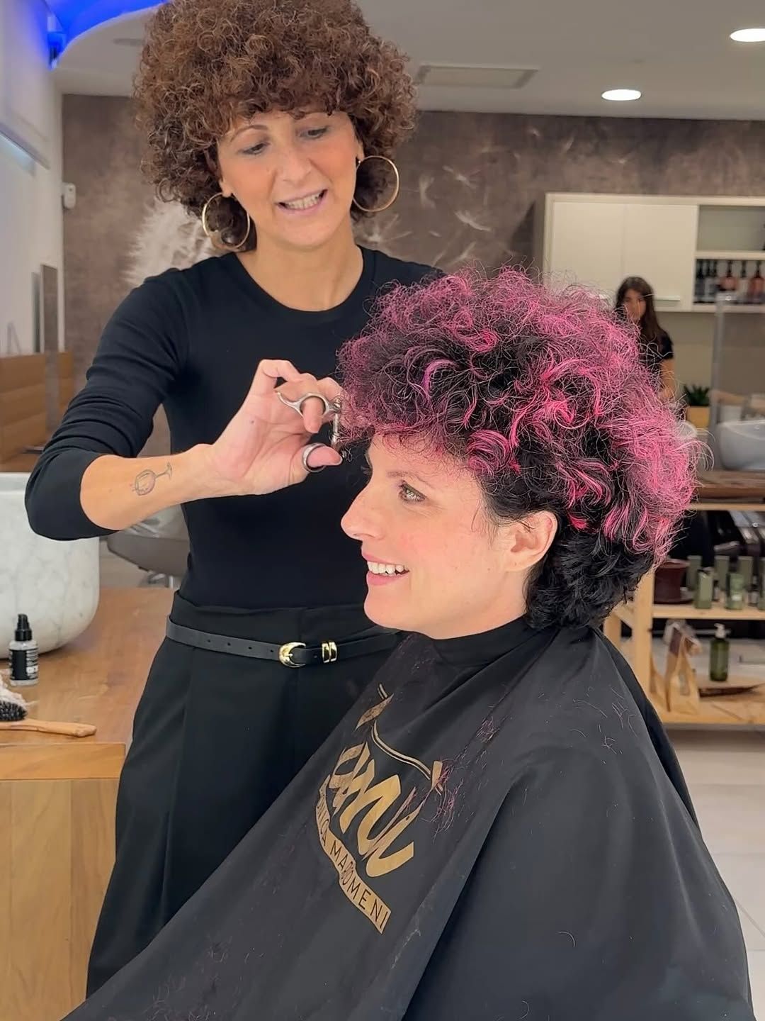 Tagliere di salumi su un tavolo con vista sulle montagne, sole splendente e cielo azzurro.