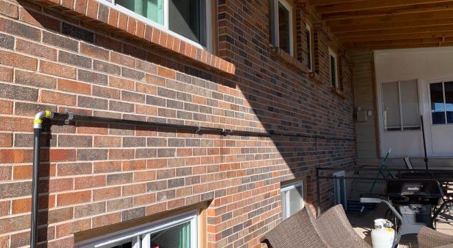 A brick building with a patio area and chairs in front of it.