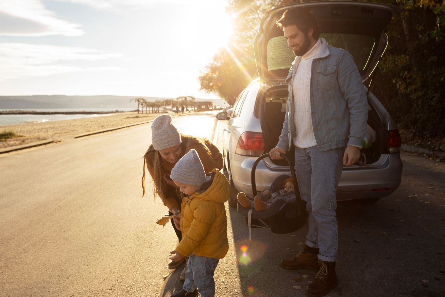 A family is standing next to a car on the side of the road.