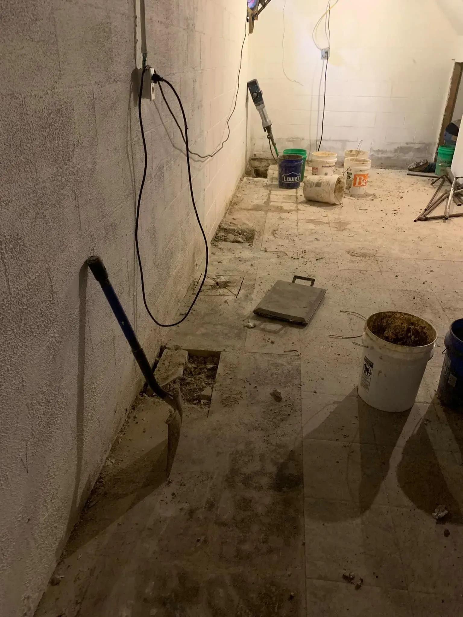 Dusty unfinished room with tools, buckets, and construction debris on the floor
