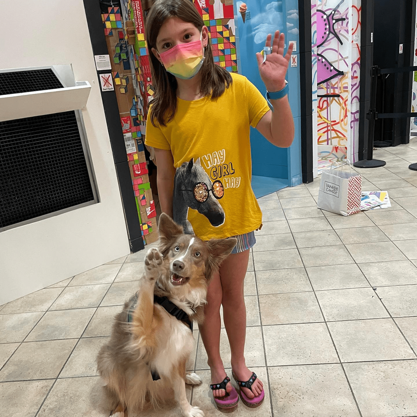 young girl waving with a dog