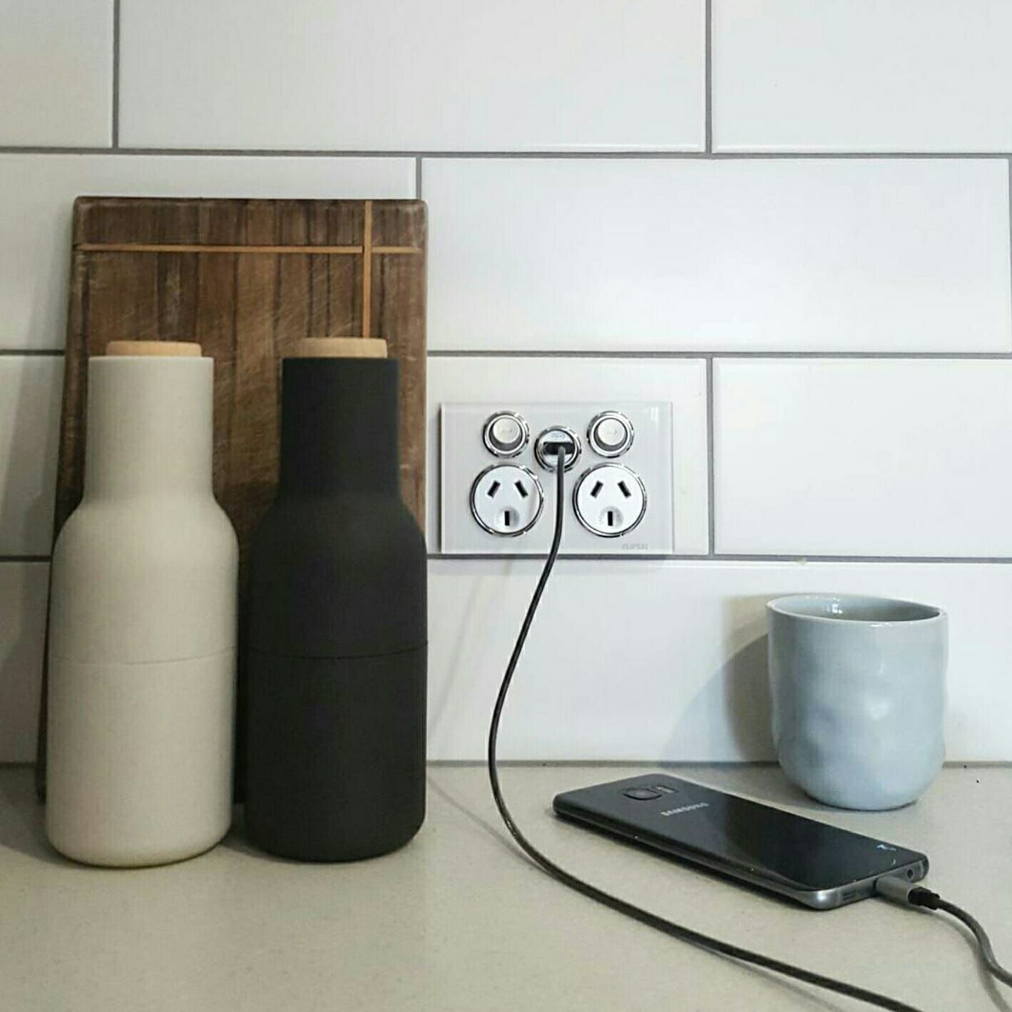 Phone Plugged Into An Outlet Next To A Bottle — Stand Fast Electrical Pty Ltd in Warwick, QLD