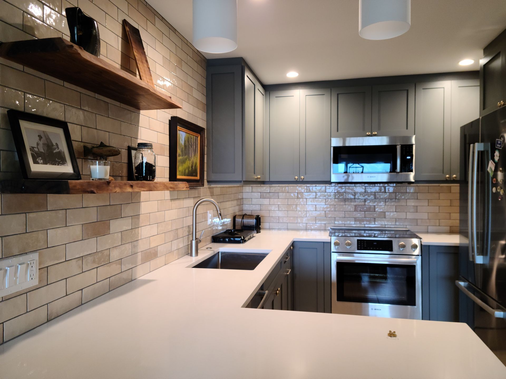 A kitchen with stainless steel appliances and gray cabinets