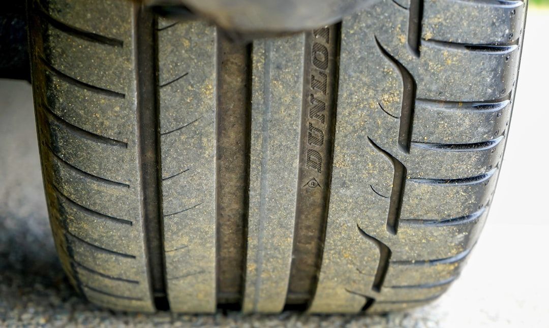 Close-up of a worn car tire tread with visible center grooves and side wear.