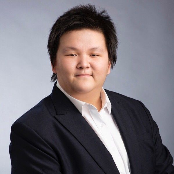 A woman in a suit and white shirt is smiling for the camera