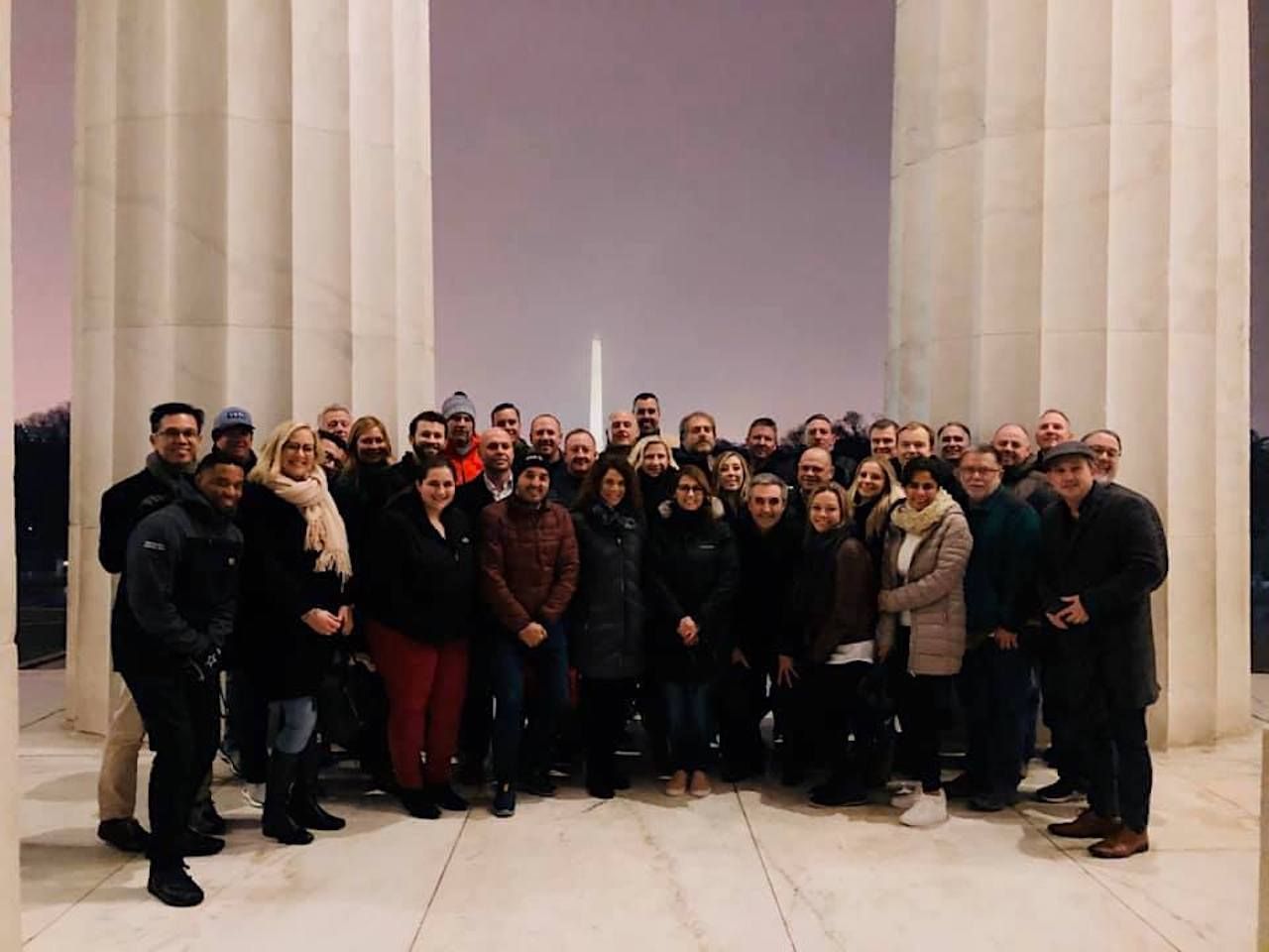 Lincoln Memorial at night, illuminated by lights, with the Lincoln statue visible in the center.
