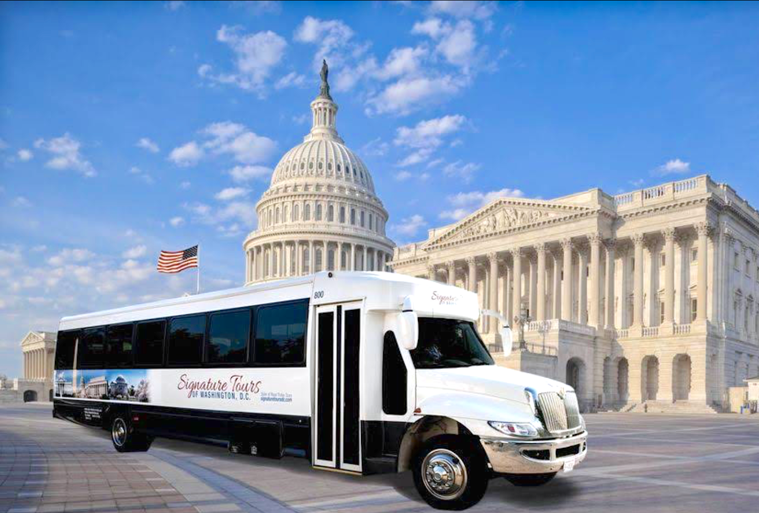 White tour bus with cityscape mural on the side, parked on a road.