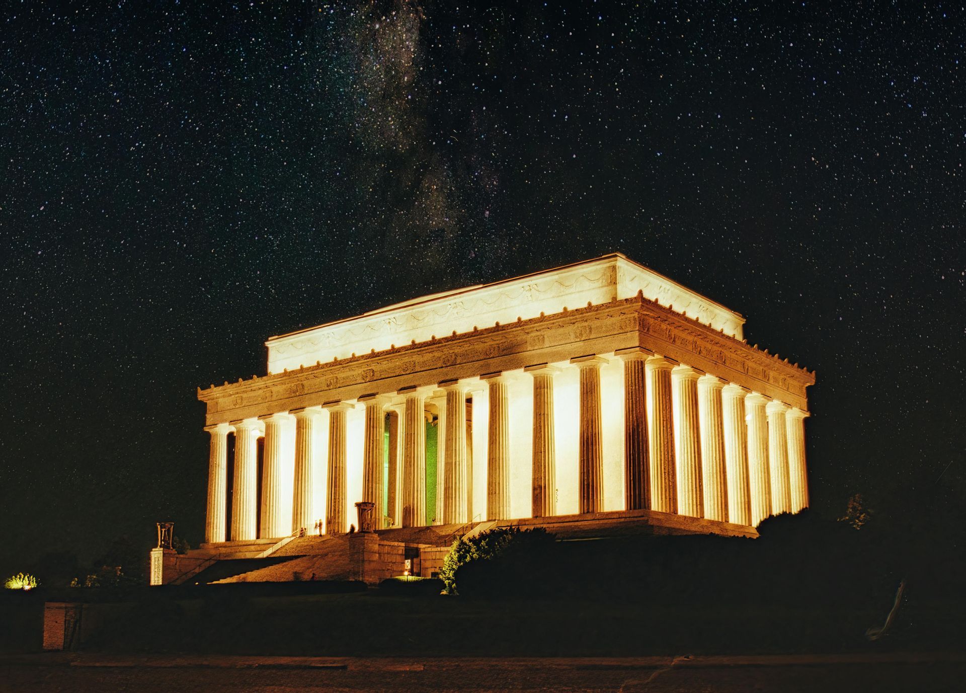 Lincoln Memorial at night, illuminated, under a starry sky.