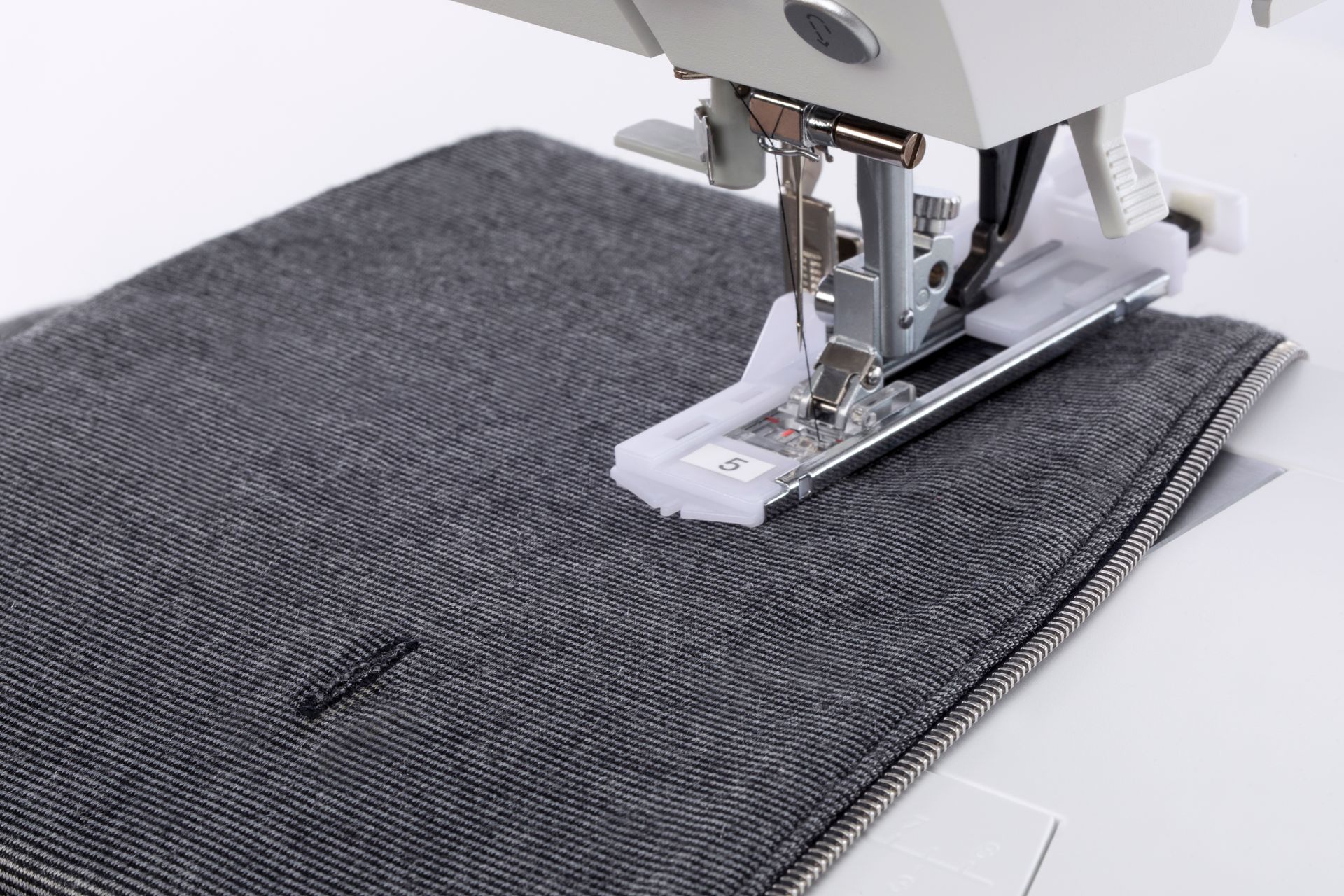 A close up of a sewing machine stitching a piece of fabric.