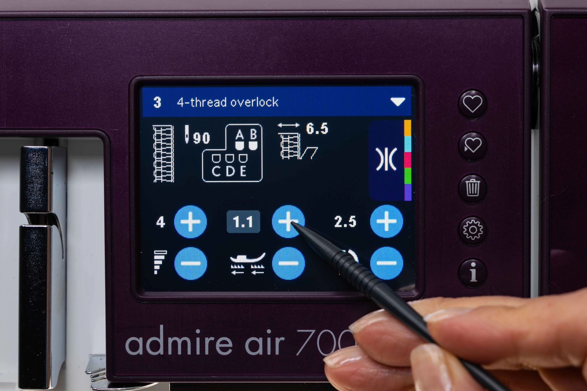 A person is pointing at a screen on a sewing machine that says admire air 700