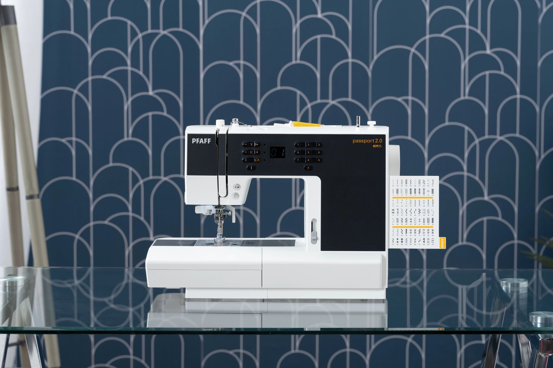 A sewing machine is sitting on top of a glass table.