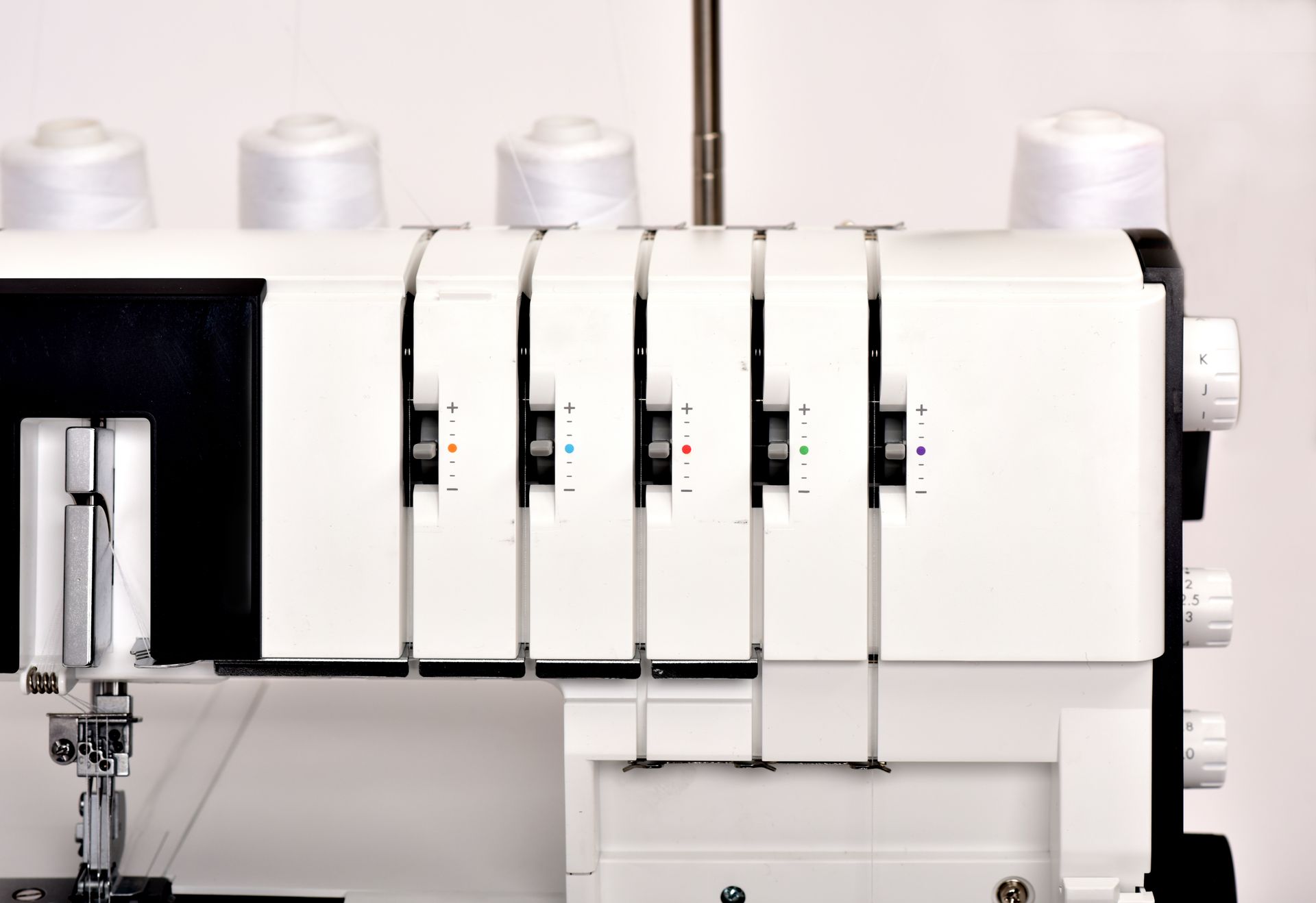 A white sewing machine is sitting on a white surface