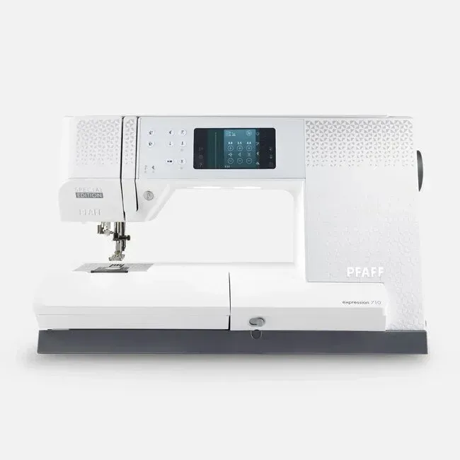 A white sewing machine is sitting on a white surface.
