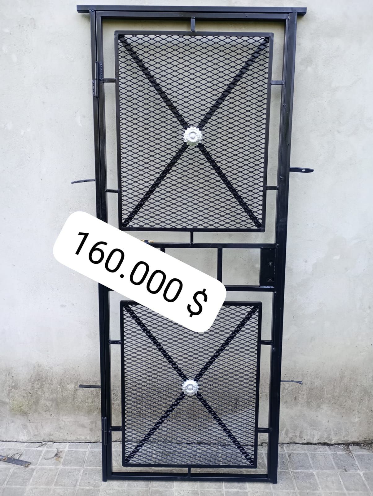 Puerta de seguridad de metal negra con malla y precio: $160.000.