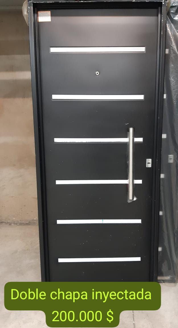 Puerta metálica de color negro con rayas horizontales blancas y tirador plateado, rotulada