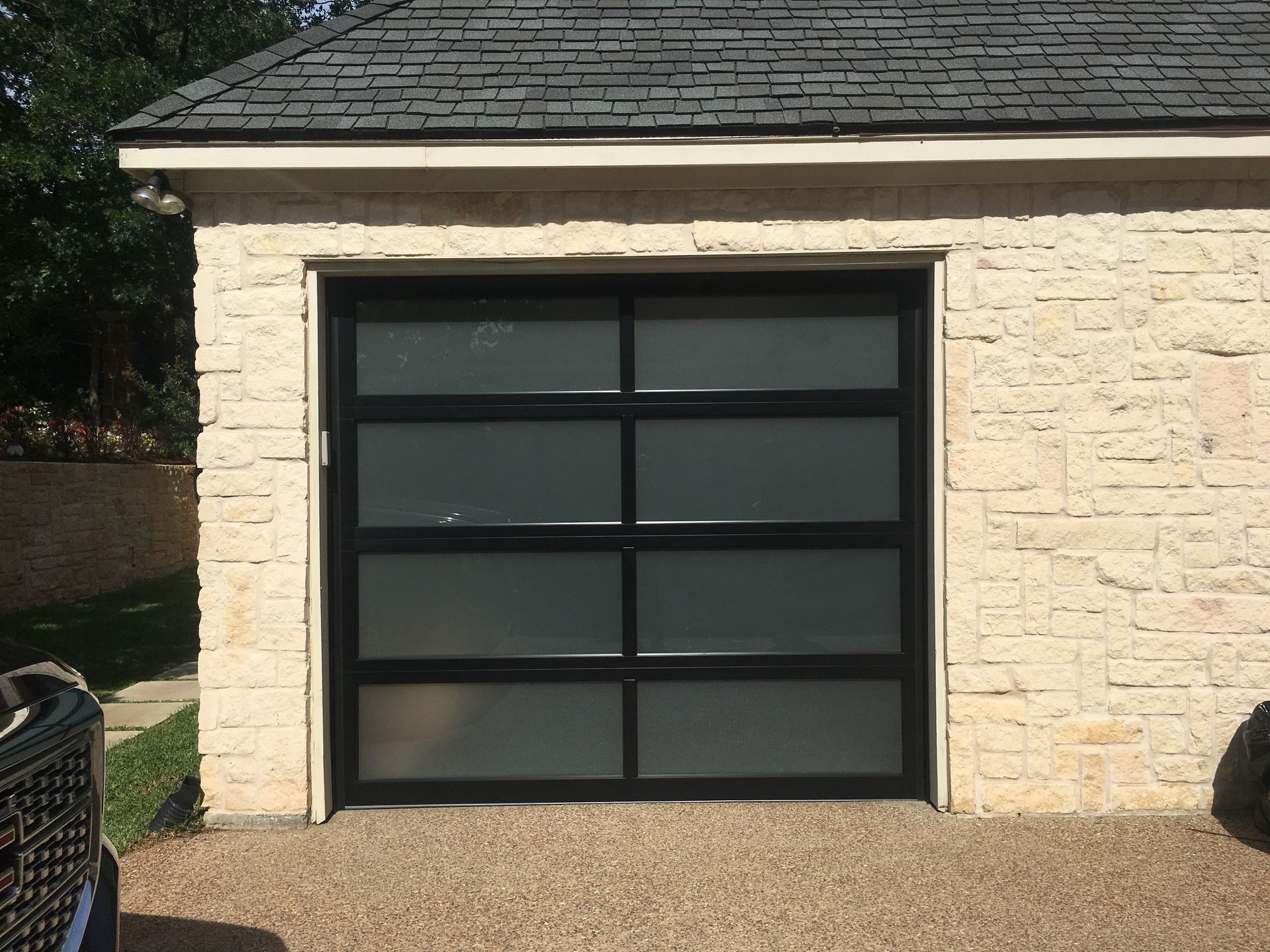 A large house with three garage doors and a driveway.