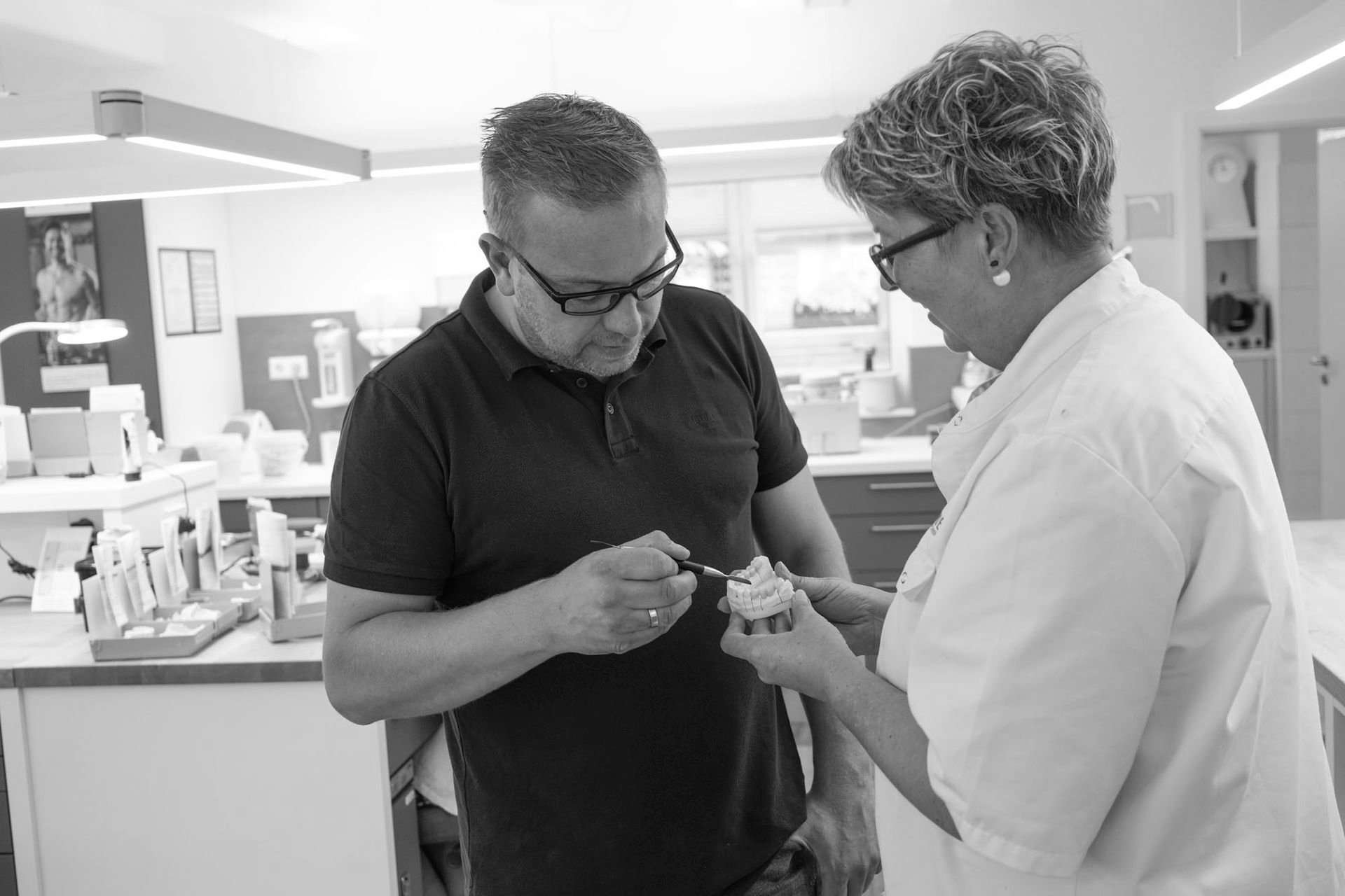 Thomas Runde mit Zahntechnikerin mit einer Zahnprothese