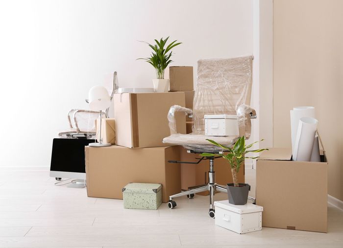 A room filled with lots of cardboard boxes and a chair.