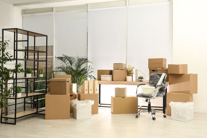 A room filled with lots of cardboard boxes and furniture.