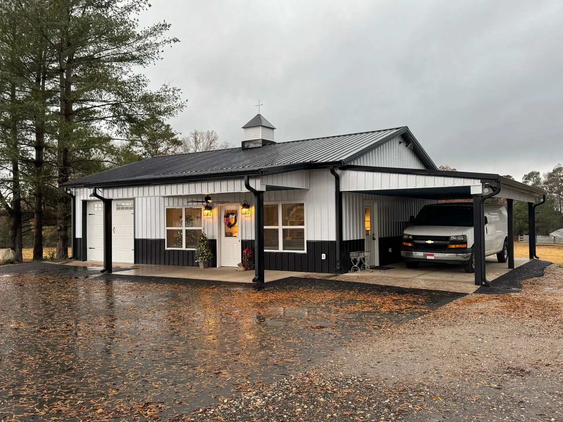A white and black house with a van parked in front of it.