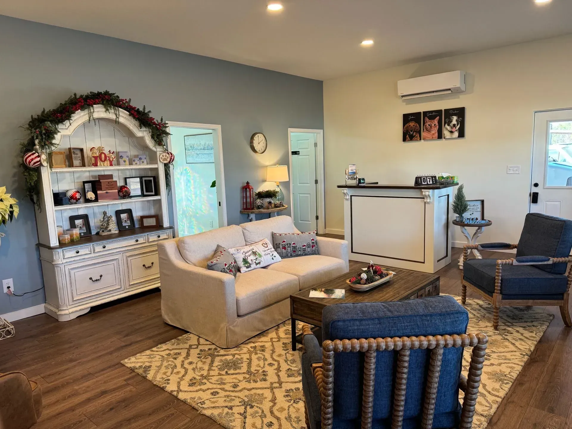 A living room with a couch , chairs , coffee table and hutch.
