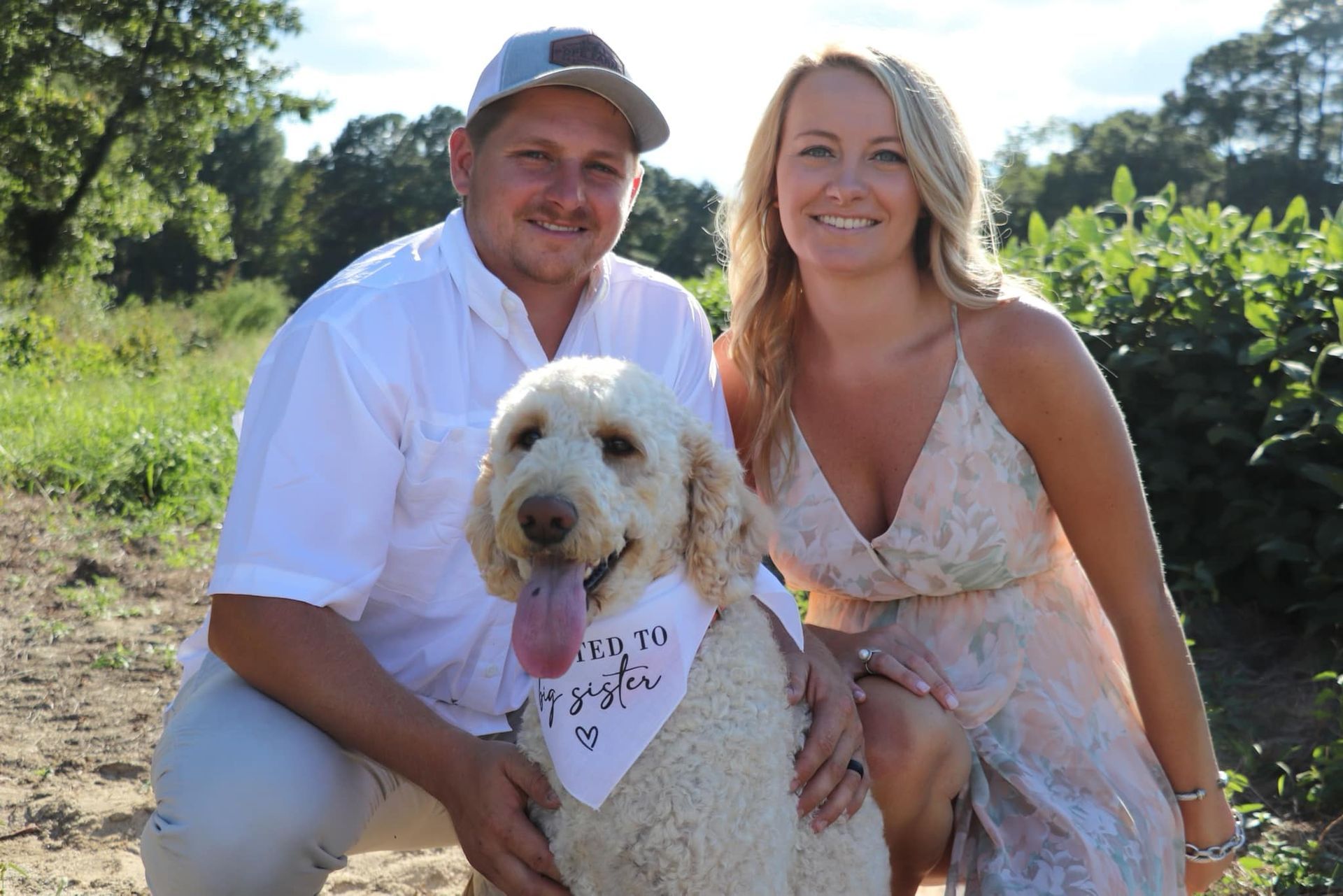 A man and a woman are posing for a picture with their dog.
