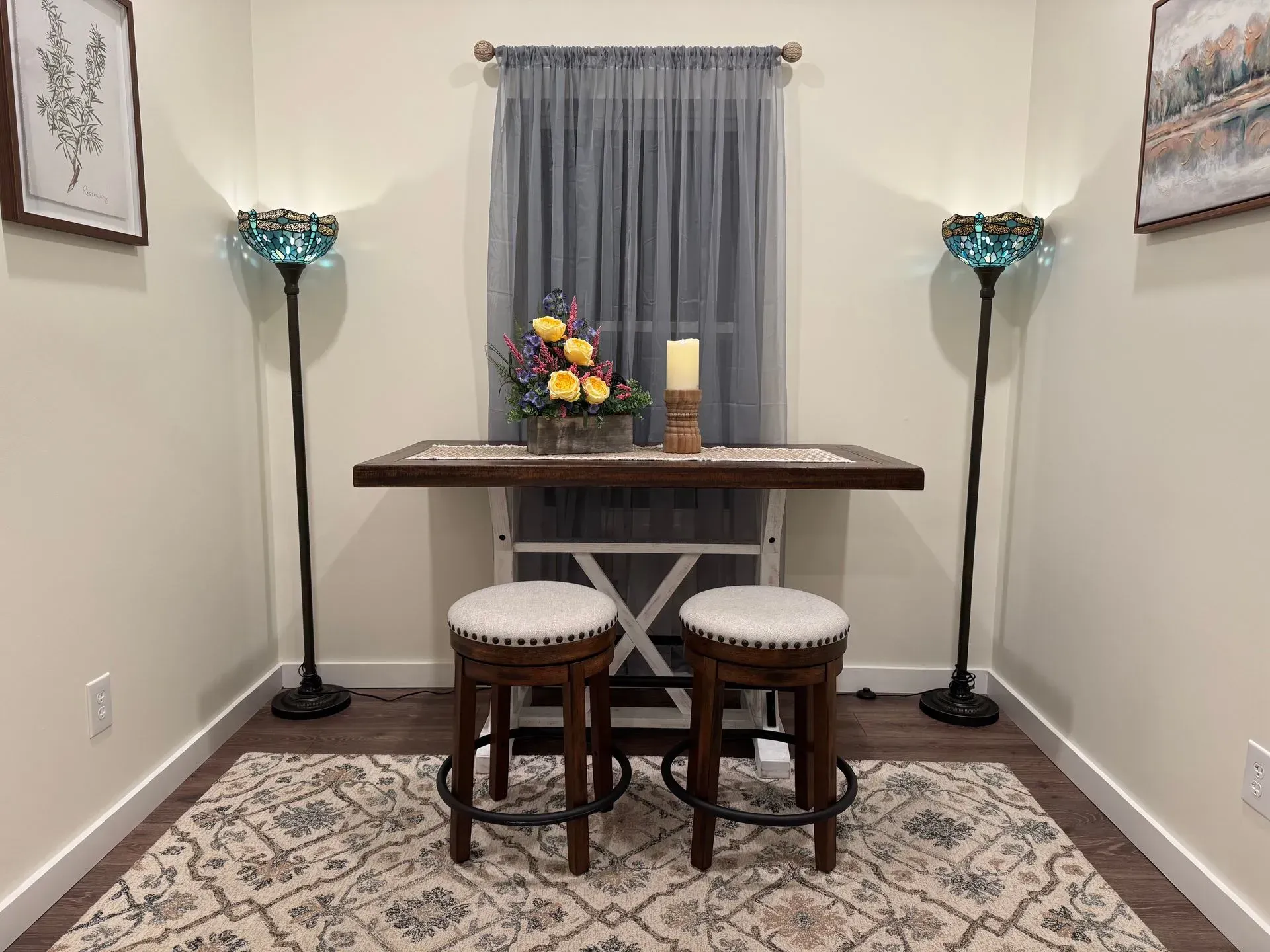 A room with a table and two stools in it.