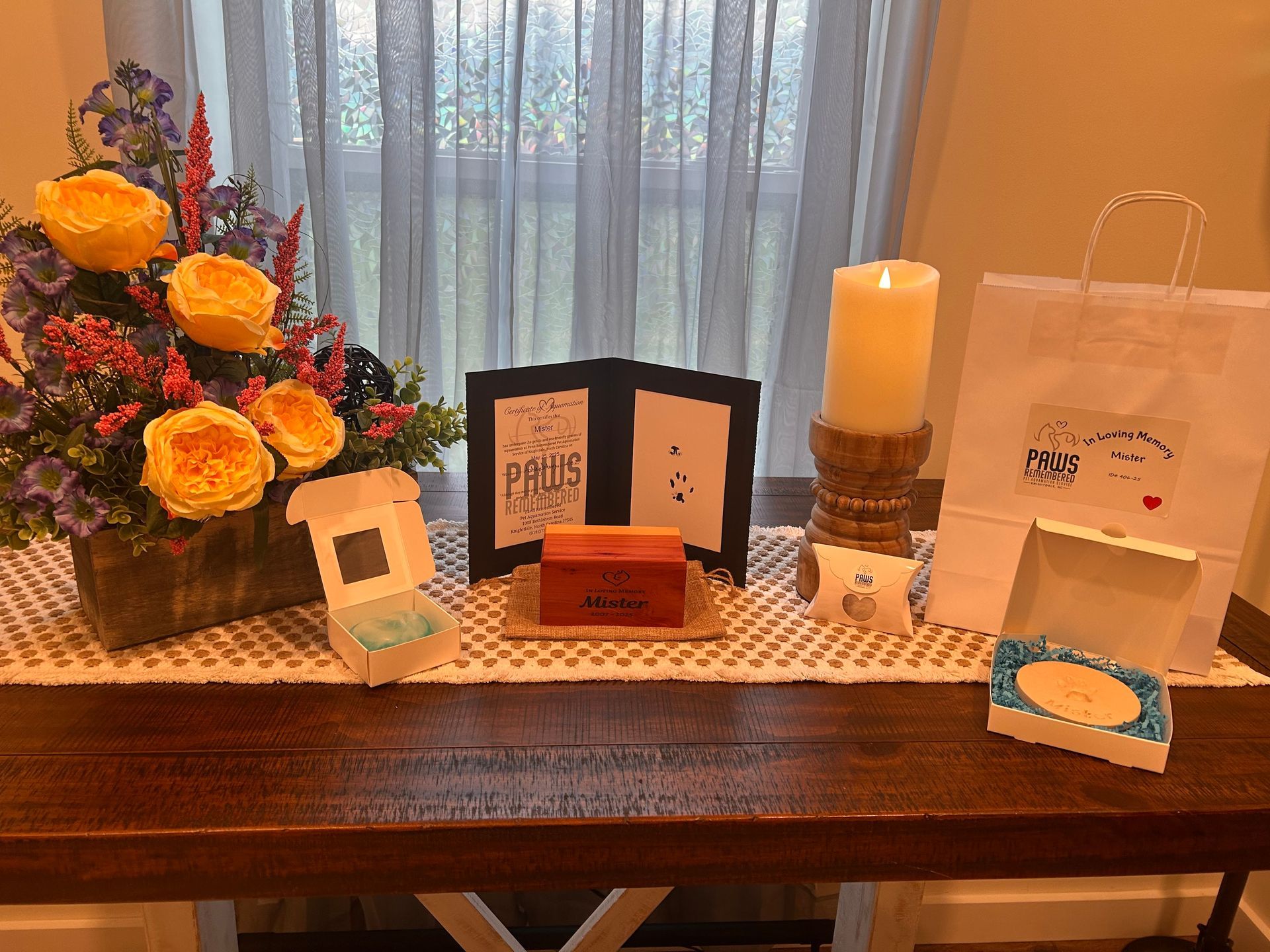 A table with a vase of flowers and candles on it